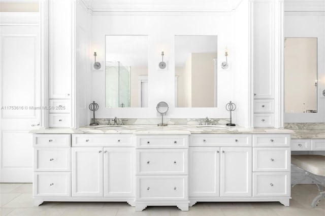 bathroom with a sink, walk in shower, ornamental molding, and double vanity