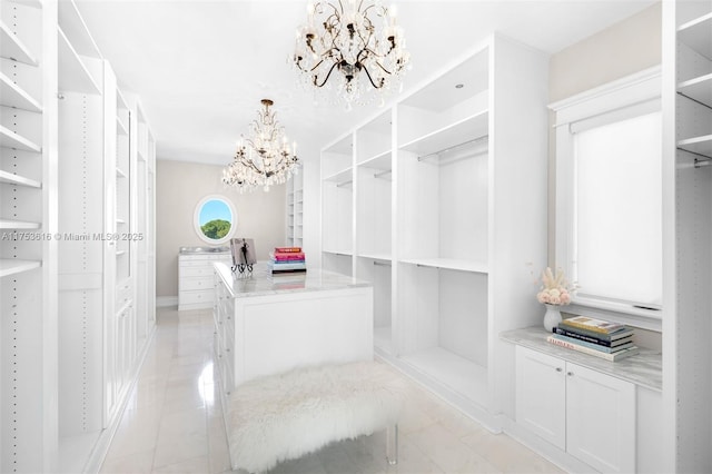 walk in closet featuring light tile patterned floors and a chandelier