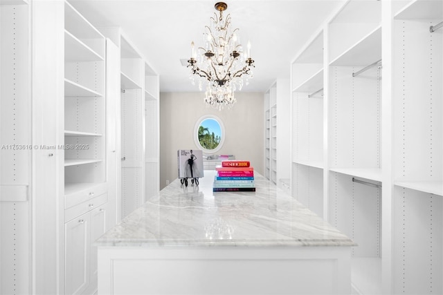 walk in closet with an inviting chandelier