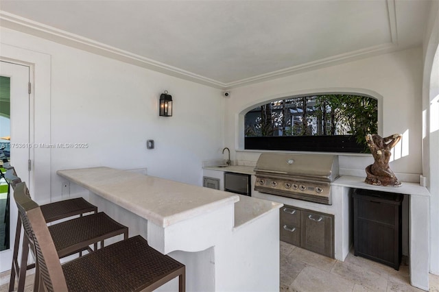 view of patio with area for grilling, exterior kitchen, outdoor wet bar, and a sink