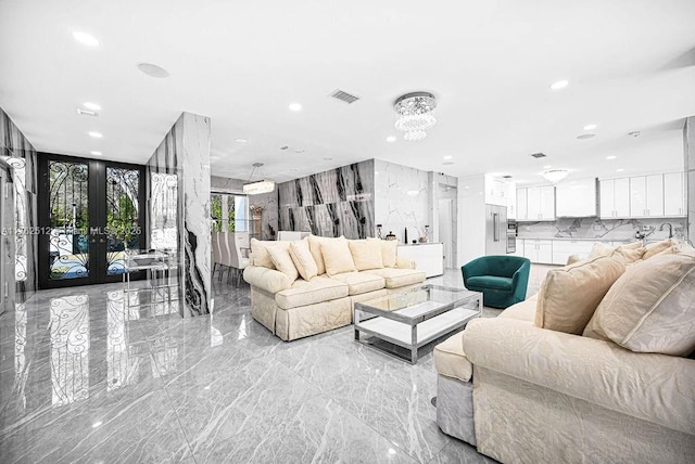 living area featuring visible vents, recessed lighting, french doors, a notable chandelier, and marble finish floor