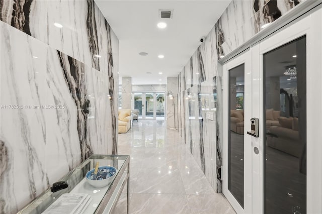 corridor with visible vents, french doors, and marble finish floor