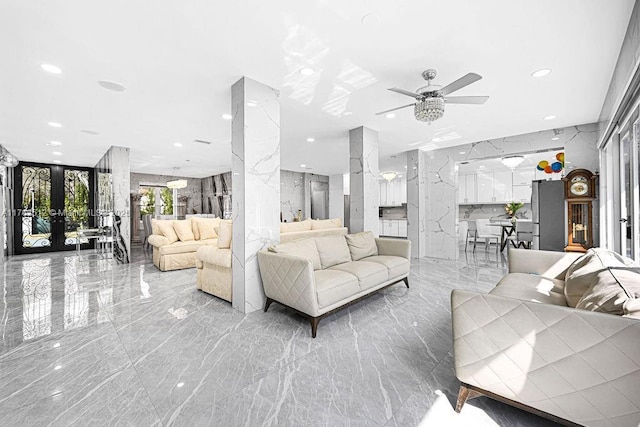 living area with recessed lighting, marble finish floor, stone wall, and decorative columns