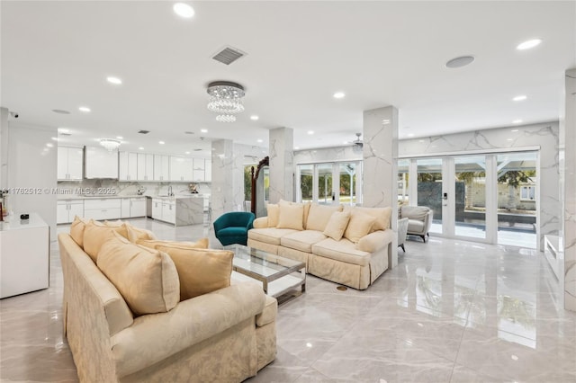 living area featuring visible vents, recessed lighting, a notable chandelier, and marble finish floor