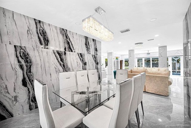 dining area with stone wall, visible vents, recessed lighting, ceiling fan, and marble finish floor