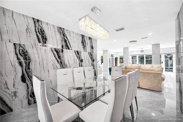 dining area with recessed lighting, stone wall, marble finish floor, ceiling fan with notable chandelier, and visible vents