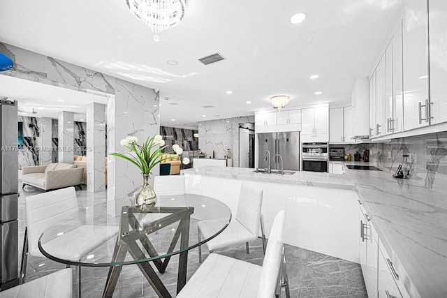 dining space with recessed lighting, visible vents, marble finish floor, and stone wall