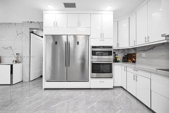 kitchen with visible vents, white cabinets, and stainless steel appliances