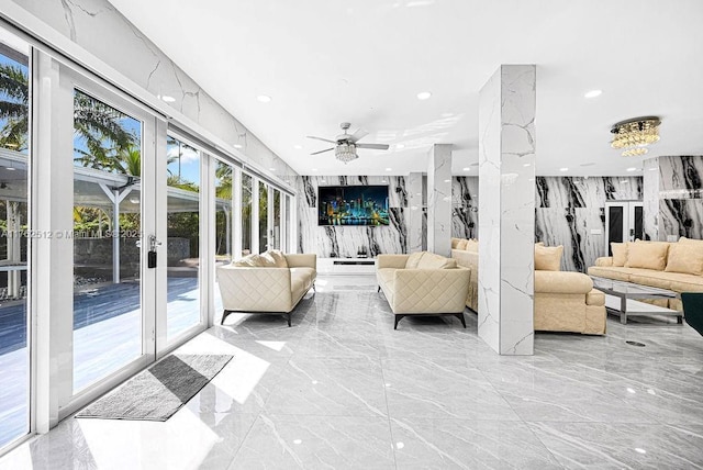 living area featuring stone wall, recessed lighting, and marble finish floor