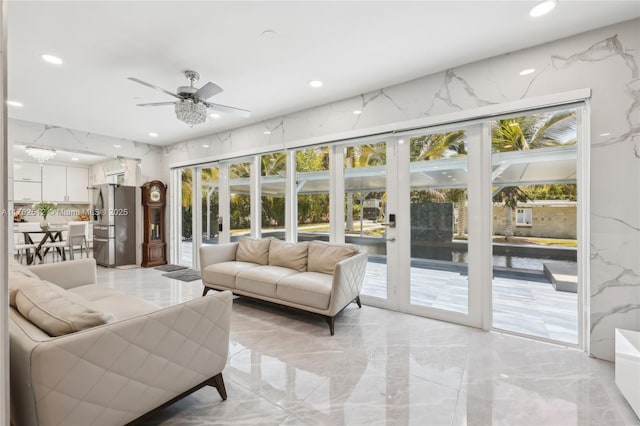living room with ceiling fan, recessed lighting, and marble finish floor
