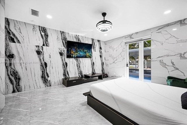 bedroom with recessed lighting, marble finish floor, stone wall, and access to exterior