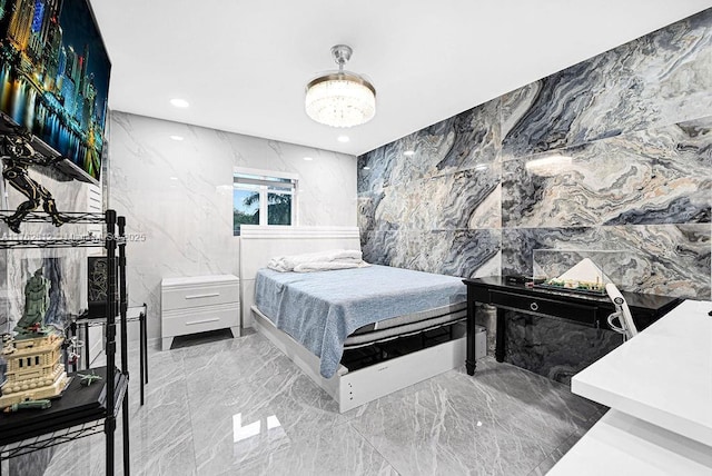 bedroom with stone wall, recessed lighting, tile walls, a notable chandelier, and marble finish floor