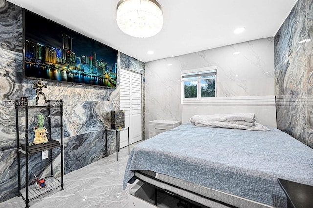 bedroom featuring recessed lighting, marble finish floor, stone wall, and tile walls