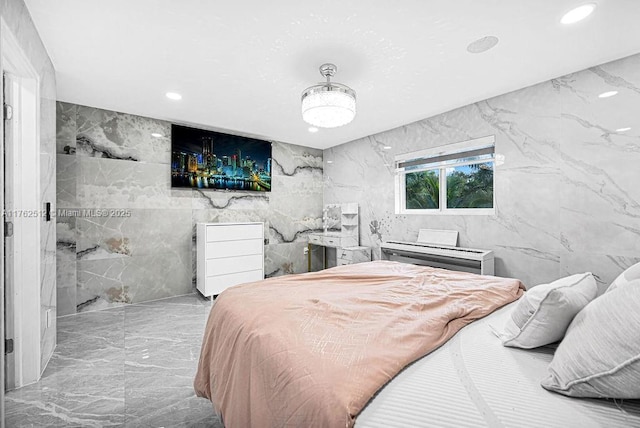 bedroom with recessed lighting, tile walls, marble finish floor, and stone wall