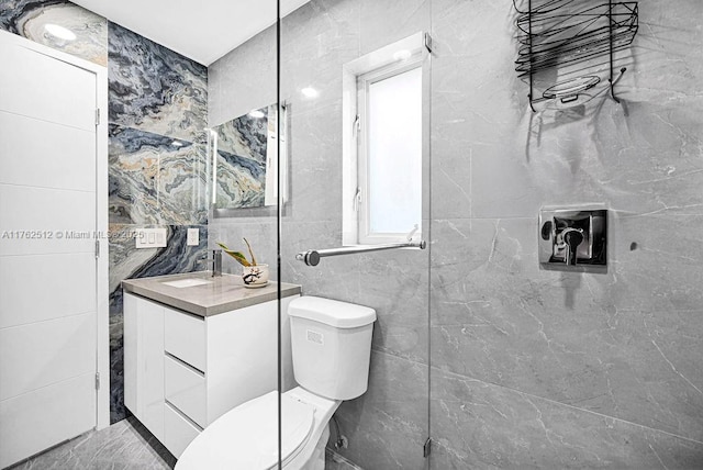 bathroom featuring vanity, tile walls, and toilet