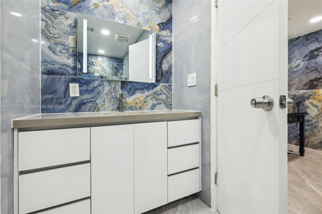 bathroom featuring vanity and tile walls