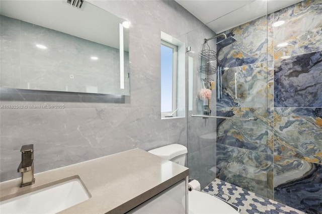 full bath featuring visible vents, toilet, tile walls, vanity, and tiled shower