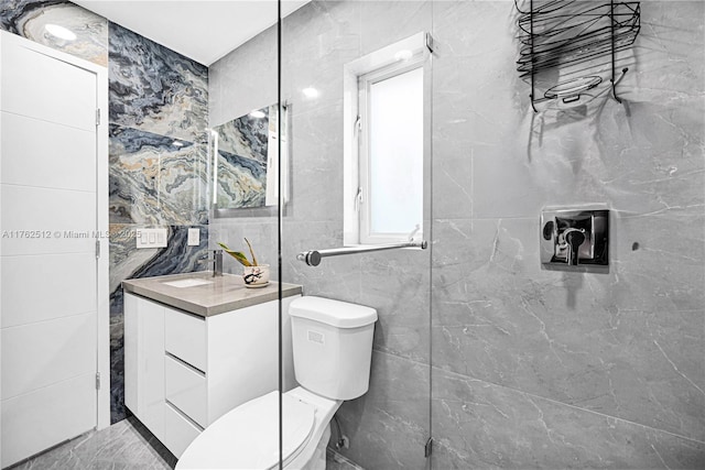 bathroom featuring toilet, vanity, and tile walls