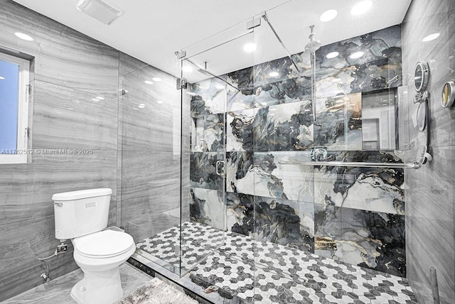 bathroom featuring visible vents, a shower stall, tile walls, toilet, and marble finish floor