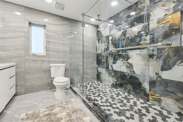 bathroom featuring tile walls, a shower stall, toilet, marble finish floor, and visible vents