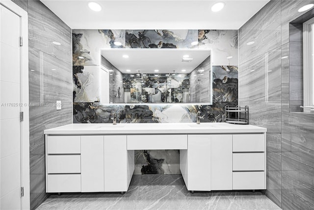 full bathroom featuring tile walls, recessed lighting, double vanity, and marble finish floor