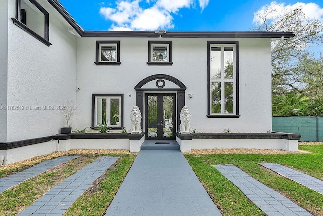 doorway to property featuring french doors and stucco siding