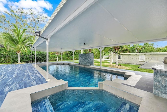 pool featuring an in ground hot tub and a patio