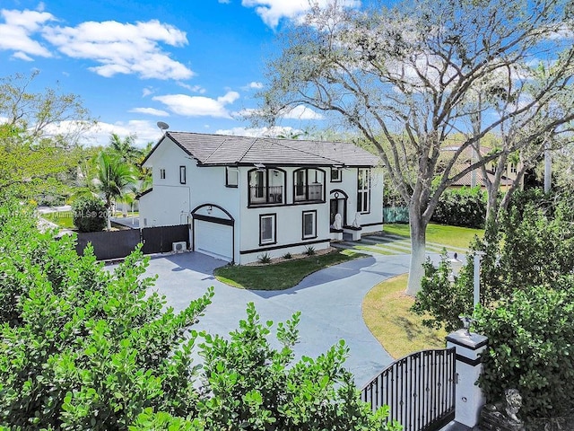 view of front of home featuring aphalt driveway, stucco siding, a garage, and fence