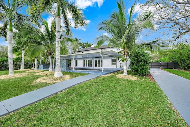 view of front facade featuring fence, a front lawn, and concrete driveway
