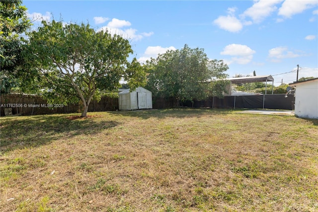 view of yard featuring an outdoor structure, a fenced backyard, and a shed