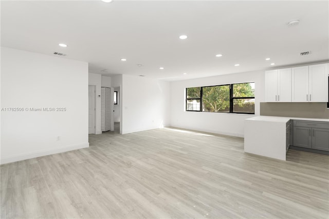 unfurnished living room with visible vents, recessed lighting, and light wood-type flooring