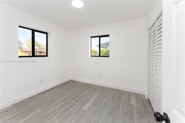 spare room with light wood-style flooring and baseboards