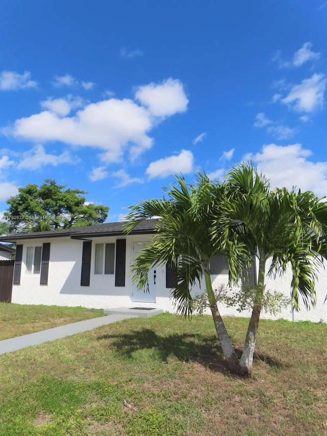 view of front of property featuring stucco siding and a front lawn