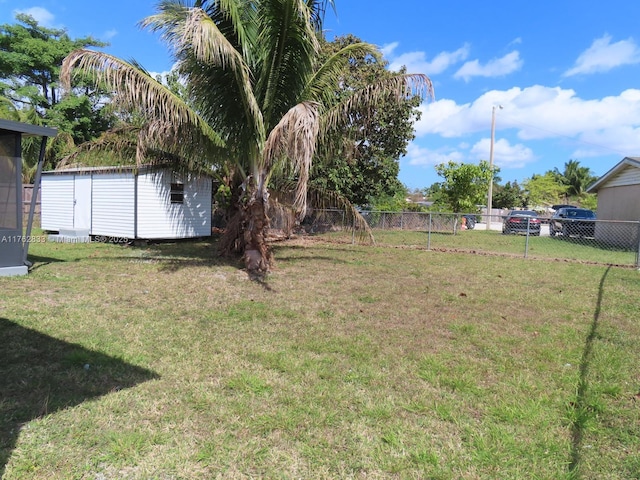 view of yard with an outbuilding, a storage shed, and fence