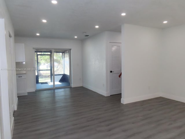 empty room with recessed lighting, baseboards, and dark wood-style flooring