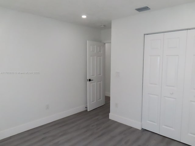 unfurnished bedroom with visible vents, baseboards, recessed lighting, wood finished floors, and a closet