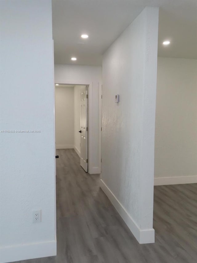 hallway featuring recessed lighting, baseboards, and wood finished floors