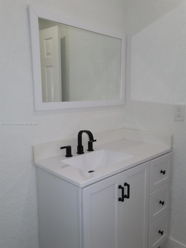 bathroom with vanity and a textured wall