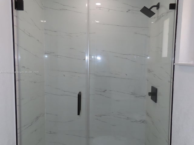 bathroom featuring a marble finish shower