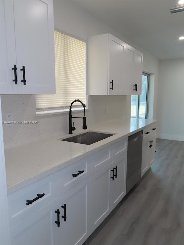 kitchen with a sink, light wood-style flooring, white cabinetry, and stainless steel dishwasher