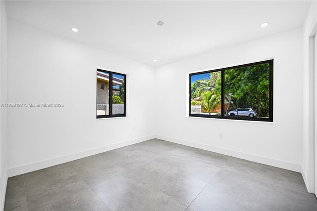 2261 SW 26th St, Miami, FL 33133 - unfurnished room featuring plenty of natural light, baseboards, recessed lighting, and concrete floors