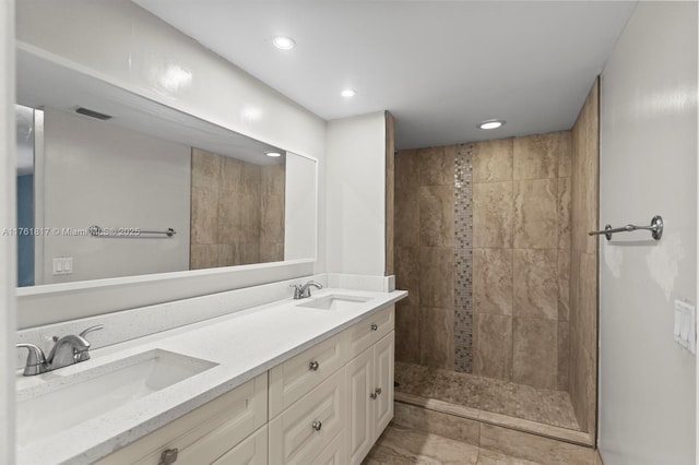 bathroom featuring double vanity, recessed lighting, a walk in shower, and a sink