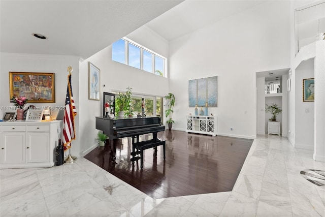 interior space featuring marble finish floor, baseboards, and ornamental molding