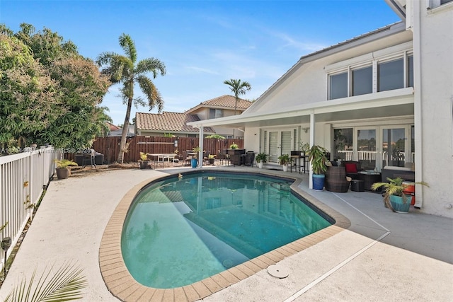 view of swimming pool with french doors, a patio, a fenced backyard, and an outdoor hangout area