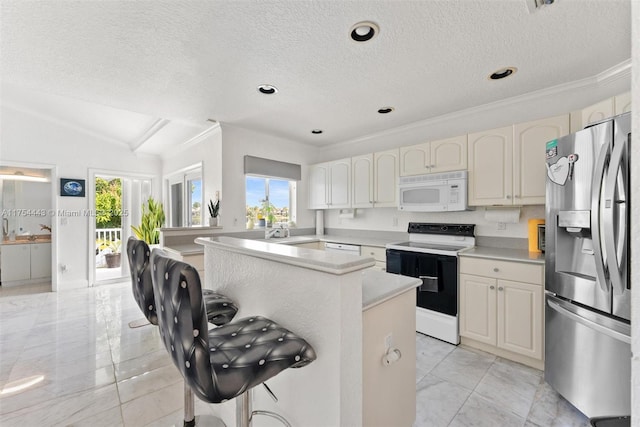 kitchen with white microwave, stainless steel refrigerator with ice dispenser, range with electric stovetop, a kitchen breakfast bar, and a center island