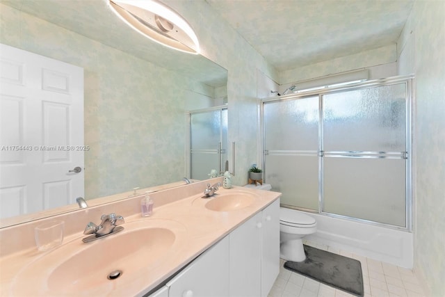 bathroom featuring double vanity, tile patterned flooring, toilet, and a sink