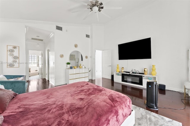 bedroom featuring visible vents, wood finished floors, baseboards, and ornamental molding