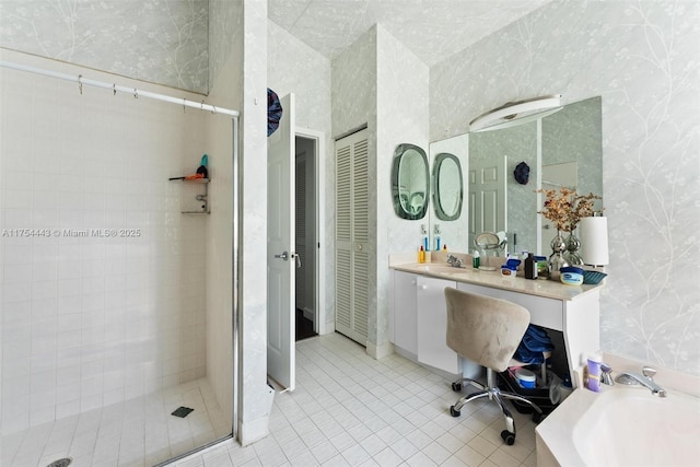 full bathroom featuring vanity, wallpapered walls, a stall shower, a closet, and tile patterned floors