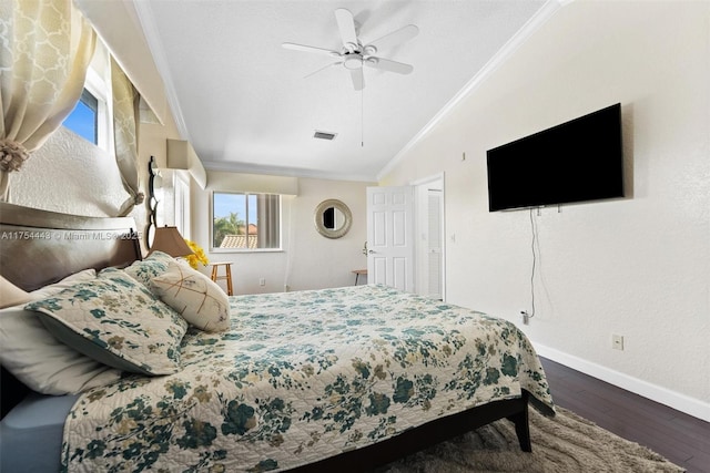 bedroom with visible vents, ornamental molding, wood finished floors, baseboards, and vaulted ceiling