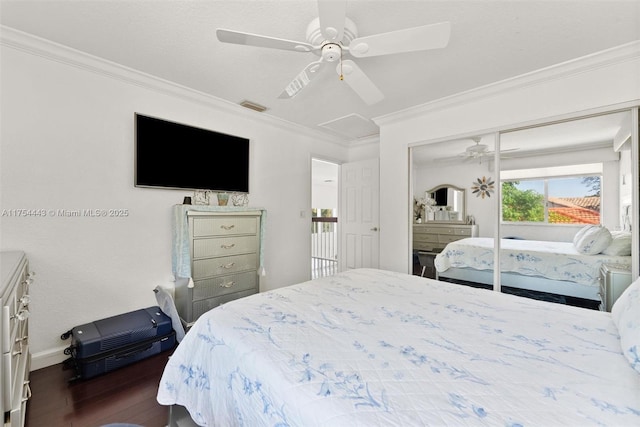 bedroom featuring visible vents, dark wood-type flooring, ornamental molding, attic access, and ceiling fan